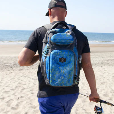 Fisherman on beach with Calcutta tackle back pack