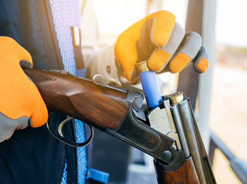 Shooter loads shotshells into over-under shotgun