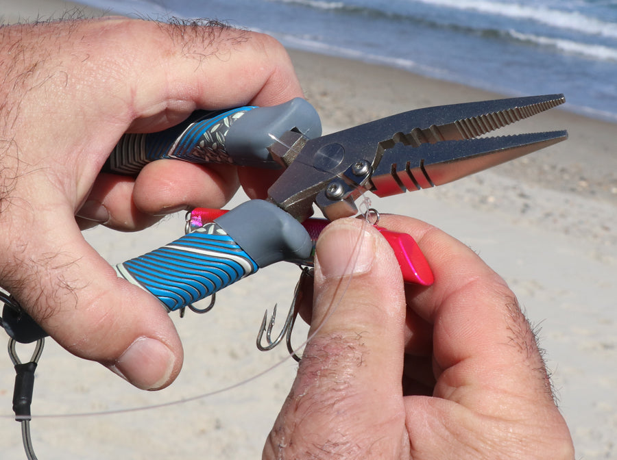 Fisherman using Squall Torque Series Stainless Steel Pliers to rig a fishing lure