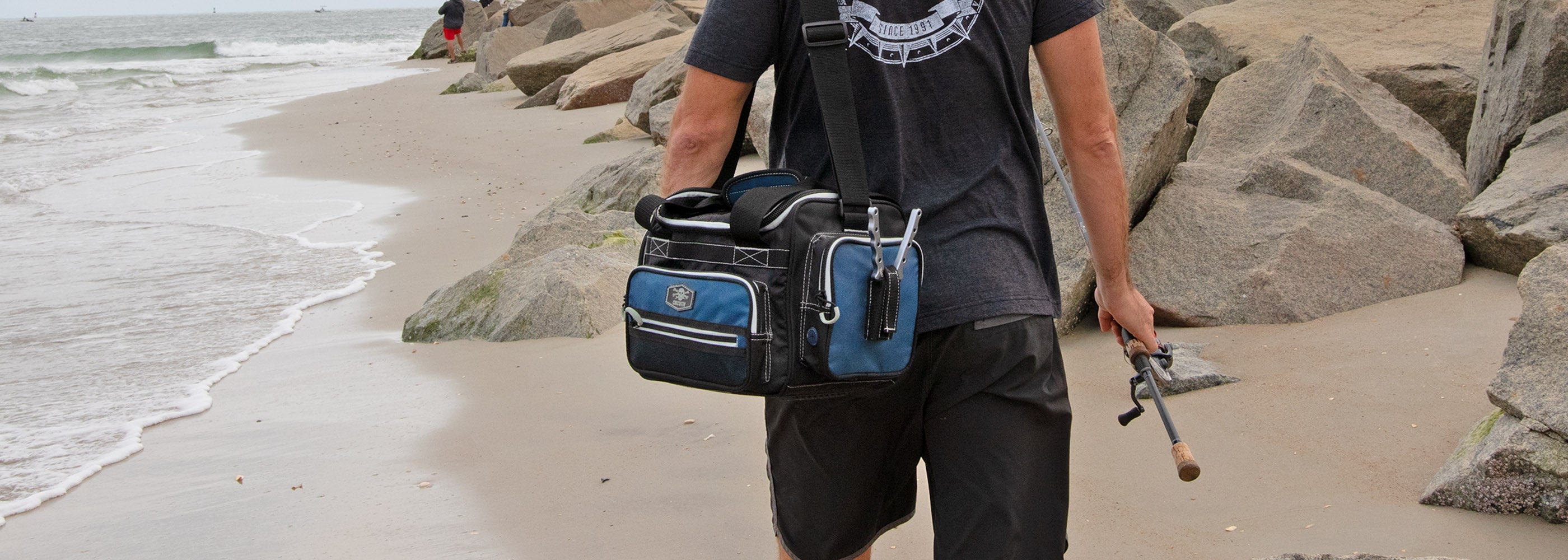 Fisherman by jetty with Calcutta explorer tackle bag